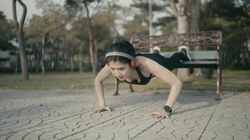 Cinematic Look Slow Motion, Asian athlete, wearing black sportswear, push-ups, stretches, warm-ups before running a marathon training session every day in the morning in the park. video