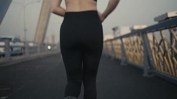 donne atletiche asiatiche in abbigliamento sportivo nero corrono ogni giorno al mattino in una città fluviale prima di gareggiare. video