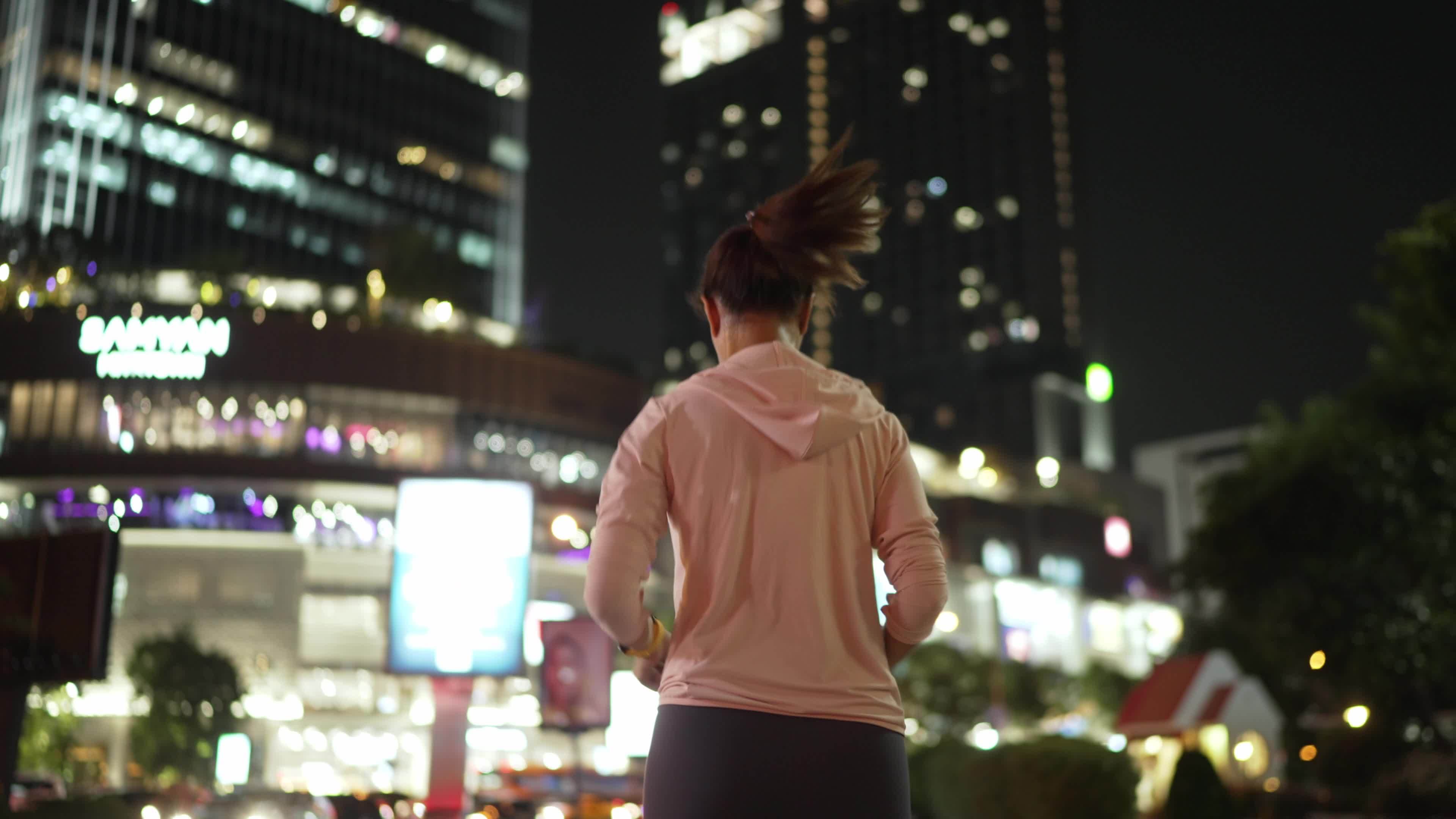 Slowmotion,Back Follow Camera View.Female athlete in hooded shirt