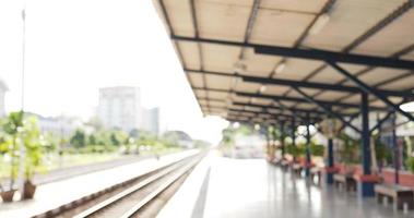 vista lateral do jovem viajante asiático esperando o trem na estação de trem. macho usando máscaras protetoras, durante a emergência covid-19. conceito de transporte, viagens e distanciamento social. video