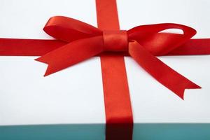 White gift box with red ribbon. Selective focus. Macro photo