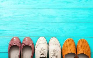 Different pairs of female shoes on blue wooden floor, Top view and copy space photo