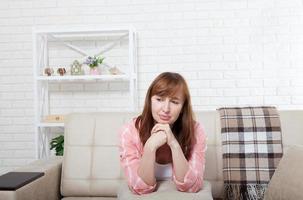 Depressed and sad middle aged woman sitting on bed, coach, sofa at home. Copy space and mock up. photo