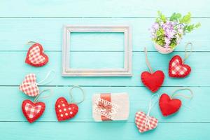 Romantic frame with copy space and accessories on blue wooden background. Top view photo