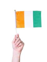 A hand holds a flag The flag of the Ivory Coast country on a white isolated background. photo