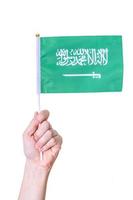 A hand holds the flag of the country of Saudi Arabia. on a white isolated background. photo