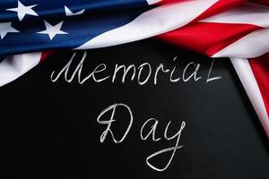 Memorial day concept. Handwritten lettering on black chalkboard and American flag. photo