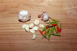 white garlic and Chili on wooden floor for cooking photo