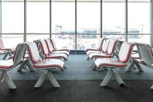 Departure lounge with empty chairs in the terminal of airport, waiting area
