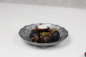 Mangosteen is a tropical fruit from Asia. Mangosteen has a distinctive sweet and sour taste. Mangosteen also has a myriad of benefits, properties, and nutritional content that is useful for health. photo