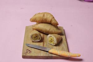 Chocolate bananas from raw materials covered with rolls of pastry dough sheets. Molen bananas with pastries are usually served with a cup of hot coffee or tea. Focus blur photo