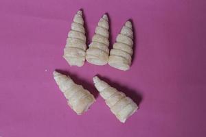 In Indonesia, this cake is known as cumcum cake. A cake shaped like a trumpet, or an ice cream cone. The perfect combination of a dry cake studded with sugar, plus a delicious cream vanilla filling. photo