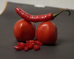 The combination of fresh tomatoes, red chilies and eggs forms a smiling face. Cooking ingredients ready to be served. focus blur, background inspiration. black and red color combination. photo