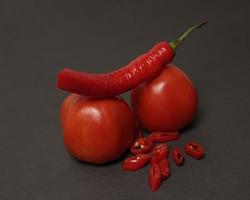 The combination of fresh tomatoes, red chilies and eggs forms a smiling face. Cooking ingredients ready to be served. focus blur, background inspiration. black and red color combination. photo