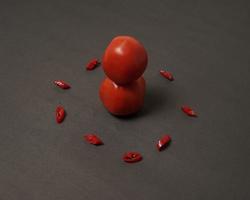 The combination of fresh tomatoes, red chilies and eggs forms a smiling face. Cooking ingredients ready to be served. focus blur, background inspiration. black and red color combination. photo