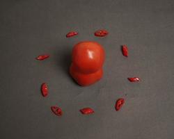 la combinación de tomates frescos, chiles rojos y huevos forma una cara sonriente. ingredientes de cocina listos para ser servidos. desenfoque de enfoque, inspiración de fondo. combinación de colores negro y rojo. foto