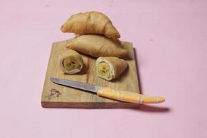 Chocolate bananas from raw materials covered with rolls of pastry dough sheets. Molen bananas with pastries are usually served with a cup of hot coffee or tea. Focus blur photo