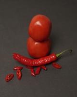 The combination of fresh tomatoes, red chilies and eggs forms a smiling face. Cooking ingredients ready to be served. focus blur, background inspiration. black and red color combination. photo