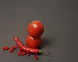 The combination of fresh tomatoes, red chilies and eggs forms a smiling face. Cooking ingredients ready to be served. focus blur, background inspiration. black and red color combination. photo