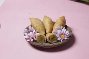 Chocolate bananas from raw materials covered with rolls of pastry dough sheets. Molen bananas with pastries are usually served with a cup of hot coffee or tea. Focus blur photo