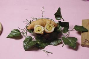 Chocolate bananas from raw materials covered with rolls of pastry dough sheets. Molen bananas with pastries are usually served with a cup of hot coffee or tea. Focus blur photo