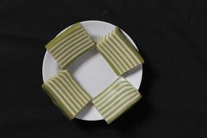 Original and pandan flavored layer cake. Layer cake is ready to accompany your morning with a glass of tea. Indonesian cake. We often see it as a side dish during Eid. Sweet and soft cake. Focus blur. photo