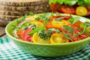 Summer tomato salad with basil, pesto and arugula photo