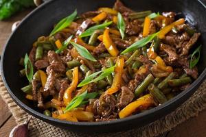 Stir frying beef with sweet peppers and green beans photo