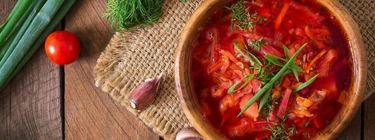 Traditional Ukrainian Russian vegetable borscht on the old wooden background photo