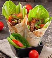 wraps de tortilla con carne y verduras frescas foto