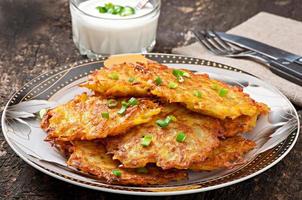 Fried potato pancakes on the old wooden background photo