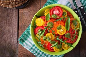 Summer tomato salad with basil, pesto and arugula photo