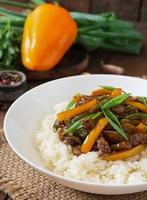 Stir frying beef with sweet peppers, green beans and rice photo