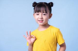 Image of Asian child posing on blue background photo