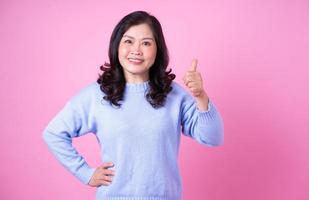 Portrait of middle aged Asian woman on pink background photo