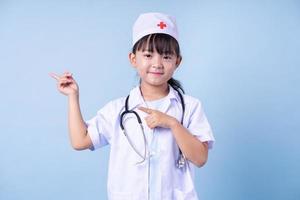 imagen de un niño asiático con uniforme médico de fondo azul foto