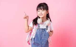 Image of Asian primary school student on pink background photo