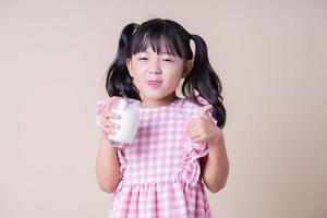 Image of Asian child drinking milk on background photo