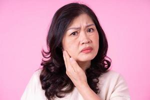 Image of middle aged Asian woman on pink background photo