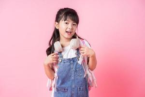Image of Asian primary school student on pink background photo