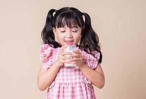 Image of Asian child drinking milk on background photo