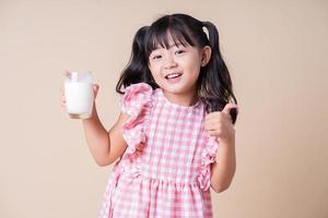 Image of Asian child drinking milk on background photo