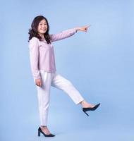 Full length image of middle aged Asian woman on blue background photo