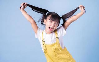 retrato de niño asiático posando sobre fondo azul foto
