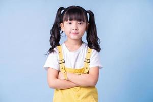 Portrait of Asian child posing on blue background photo