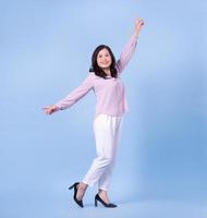 Full length image of middle aged Asian woman on blue background photo