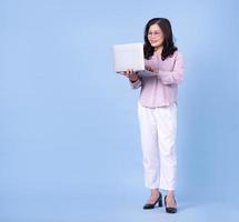 Full length image of middle aged Asian woman on blue background photo