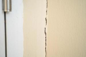 grietas de asentamiento de la pared de cemento que ocurren en las juntas de expansión en la estructura de la casa. foto