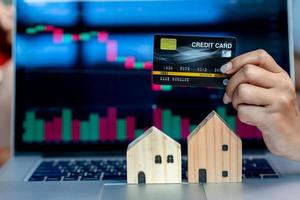 wooden house model credit card and graph photo