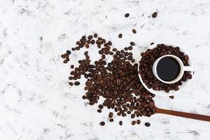 Coffee cup and coffee beans on white background. Top view photo